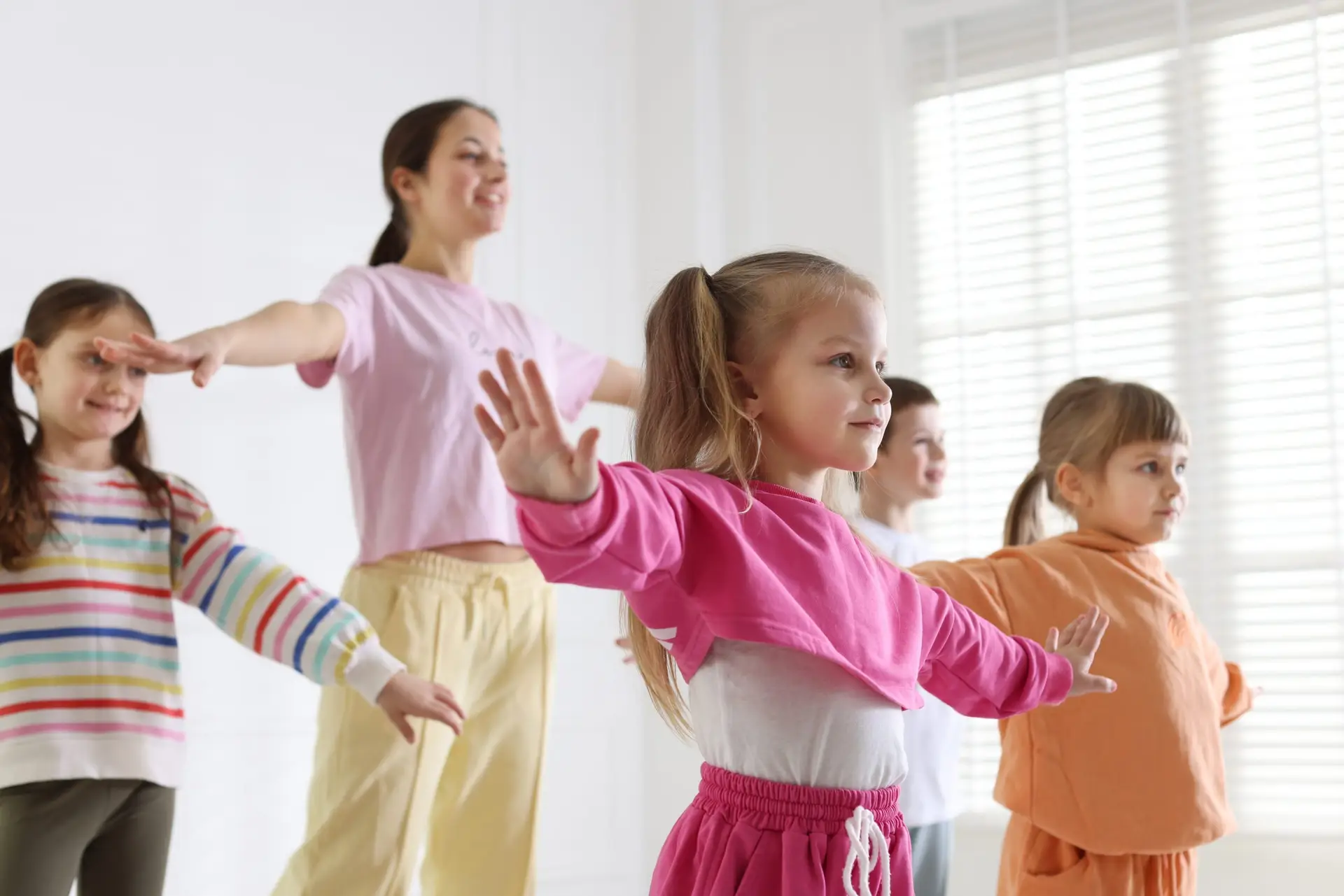 Tanzlehrerin beim spielerischen Tanzunterricht mit Kindern